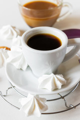 A cup of espresso and cocoa, meringue on a white background. Close-up.