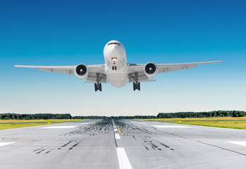 Passenger airplane landing at in good clear weather with a blue sky on a runway.