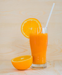 Orange and orange juice on wooden background.