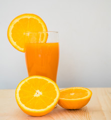 Orange and orange juice on wooden background.