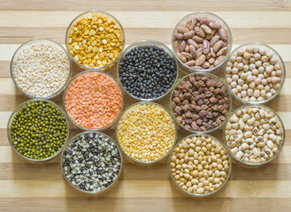Twelve bowls of lentils on a chopping board
