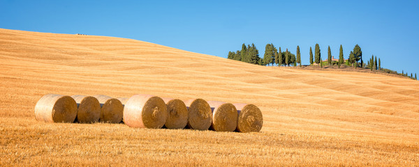 Beautiful typical panorama landscape of Val d'Orcia in Tuscany with hay bales in a field in summer,...