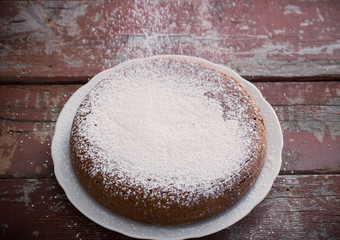 chocolate sponge cake on old wooden background.