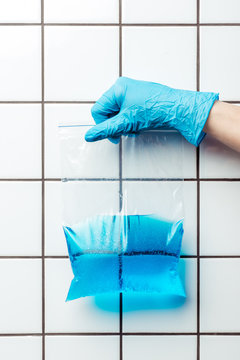 Cropped Image Of Woman In Blue Rubber Glove Holding Ziplock Plastic Bag With Water, Earth Day Concept