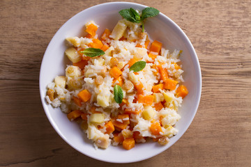 Healthy food: rice porridge with pumpkin, apples and raisins. Vegetarian or diet dish of rice and pumpkin good for breakfast. View from above, top