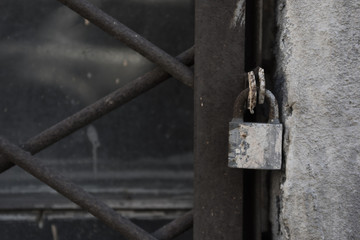 Old padlock on metal window grille close