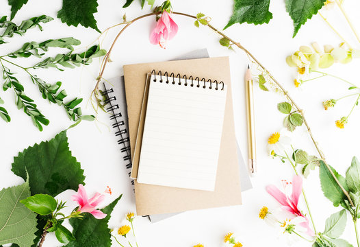 Top view flat lay empty note book with summer leaves and daisy flowers mockup. Text space