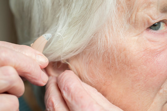 Close Up Of Senior Woman Putting In Hearing Aid