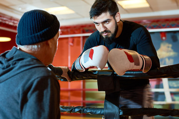 Fototapeta na wymiar Portrait of tough Middle-Eastern boxer listening to coach giving instructions during fight, copy space