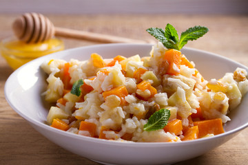 Healthy food: rice porridge with pumpkin, apples and raisins. Vegetarian or diet dish of rice and pumpkin good for breakfast