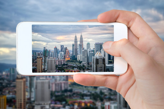 Closeup Of A Hand With Smartphone Taking A Picture Of Kuala Lumpur Skyline, Malaysia