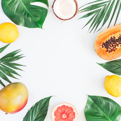 Summer tropical composition. Green palm leaves and tropical fruits on gray background. Summer concept. Flat lay, top view, copy space