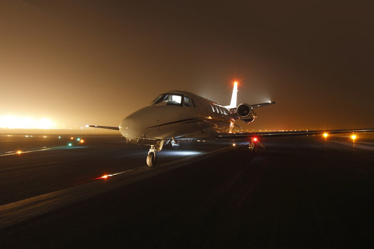 Luxury business jet ready for take off at the runway at night 