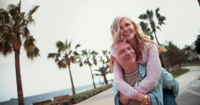 Senior wife getting a piggy back ride by husband