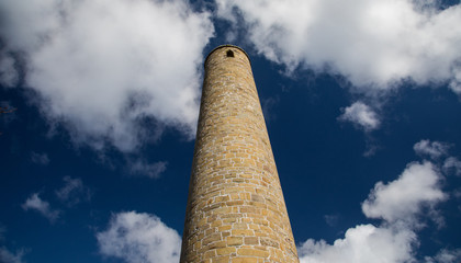 Historic and ancient Rattoo round tower near ballyduff county kerry Ireland with cloudy blue sky background