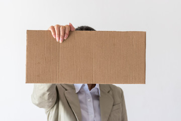A woman holds blank sign in front her face