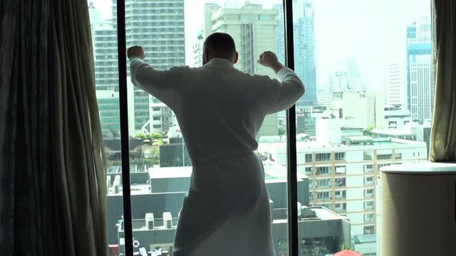 Man wearing bathrobe and dancing in fron of the window, slow motion shot at 120fps
