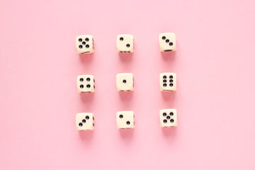 Gaming dice organized in rows on pink background in flat style. Concept for banners, web, games, web, presentation. Top view.