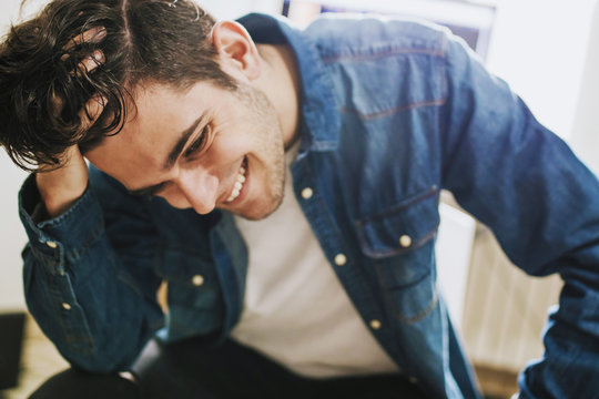 Fashionable Young Man Smiling With His Hand On His Hair, Portraits