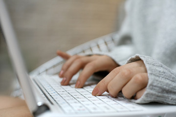 Woman typing on a laptop keyboard.