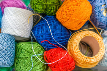 Yarn spools of varied colors placed in a disorderly manner.