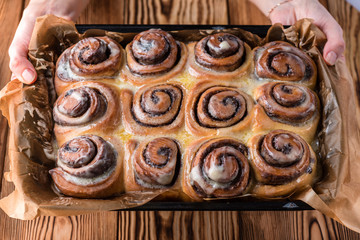Women's hands serve buns on a tray