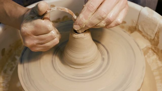 Handicraftsman create product on the circle potterswheel close up isolated. Artisan dexterity and skilfully sculpt traditional culture brown vase or cup. The creativity leisure, creating job of artist