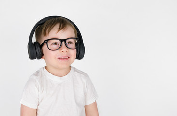 Happy little boy listening to music with headphones