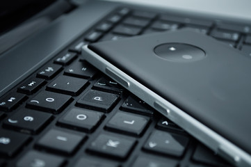 mobile phone on a laptop keyboard close-up, technology, business