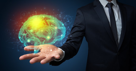 Businessman holding human brain on his hand with logistics symbols around