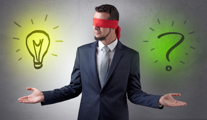 Covered eye businessman with bulb and question sign symbols around