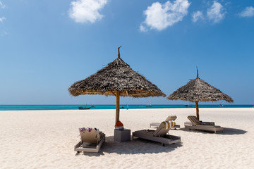 Beach Chairs and Umbrella on a beautiful island, panoramic view with much copy space,swimsuits,...