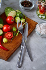 fresh vegetables on the cutting board and knife over white background, selective focus, shallow depth of field