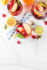 Summer cold cocktail, fruit and berry red wine sangria with apple, lemon, oranges and raspberry. light background, copy space top view