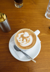 Cup of hot coffee on table