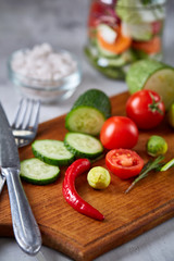 fresh vegetables on the cutting board and knife over white background, selective focus, shallow depth of field