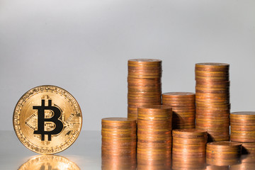 One bitcoin VS stack of coins on grey background.