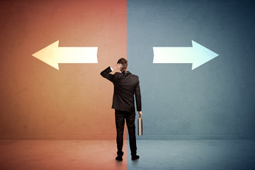 Salesman in doubt standing in front of two arrows on blue and red background concept