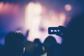 Fan taking photo of concert with a mobile phone