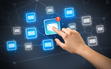 Female hand touching unread mail icon with more envelope icons around it 