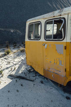 Old car close to a black gravel pile at a quarry with broken car body