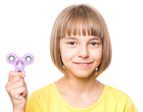 Young girl holding popular fidget spinner toy - close up portrait. Happy smiling child playing with Spinner, isolated on white background.