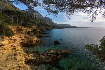 Fototapeta na wymiar Exotic seascape with crystal clear waters, beautiful mountains and blue sky. Es Caló, Mallorca. Mediterranean island