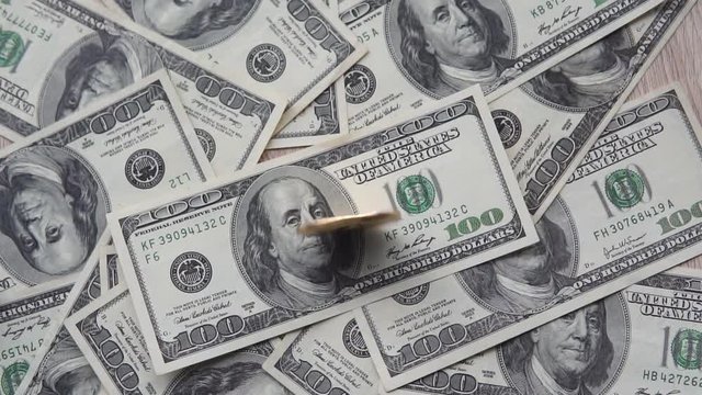 Gold golder bitcoin from the top spins on the us dollar and after spinning falls on the middle of dollar. Concept of trading cryptocurrency. Hand spinning coin over Dollar. Financial concept.