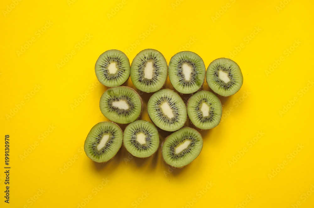 Wall mural kiwi fruit on yellow background.