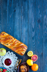 Breakfast with coffee and tea with different pastries and fruits on a wooden table