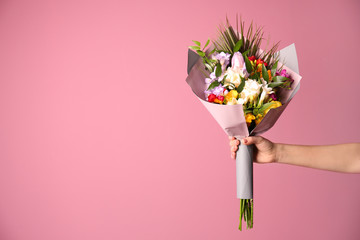 Woman with beautiful bouquet of freesia flowers on color background