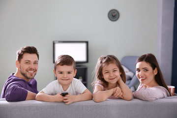 Fototapeta premium Family watching TV on sofa at home