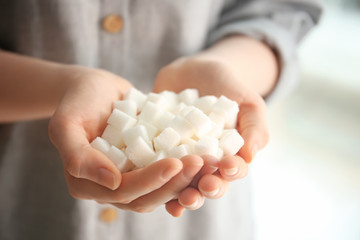 Woman holding sugar cubes, closeup