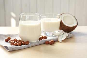 Glasses with milk substitute and nuts on kitchen table